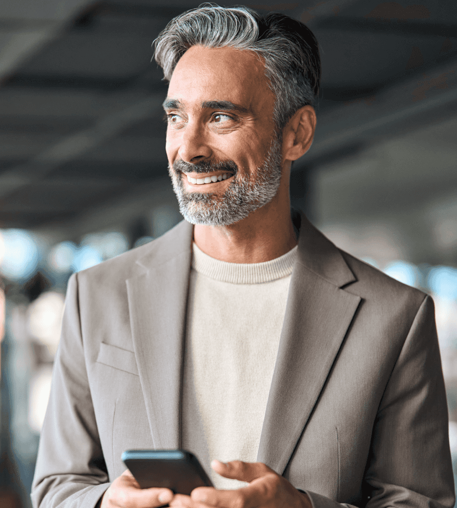 Homem segurando um celular e olhando para o horizonte